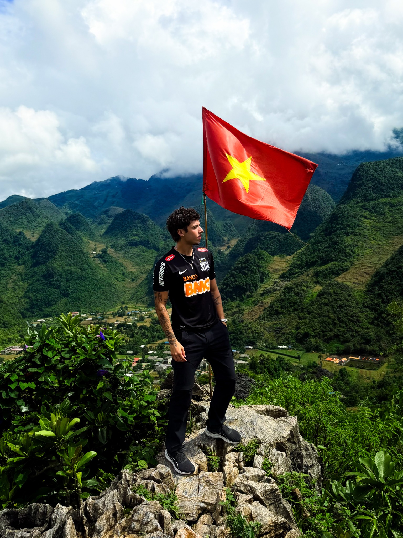 Verly diante das montanhas e da bandeira do Vietnã